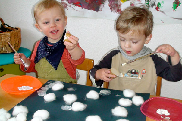 Tageskinder in der Kindertagespflege in Braunschweig basteln Schneeflocken aus Watte und Kartoffeldruck.