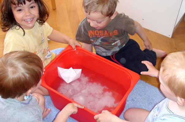 Tageskinder matschen mit Papierschiffchen im Wasser ? TiQ! Tagespflege in Querum Nicole Appel und Antje Storek, Kindertagespflege Tagesmutter Großtagespflege Braunschweig Querum