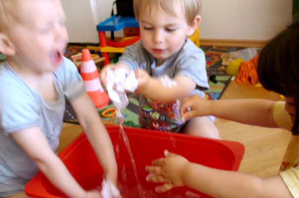 Tageskinder matschen mit Papierschiffchen im Wasser ? TiQ! Tagespflege in Querum Nicole Appel und Antje Storek, Kindertagespflege Tagesmutter Großtagespflege Braunschweig Querum